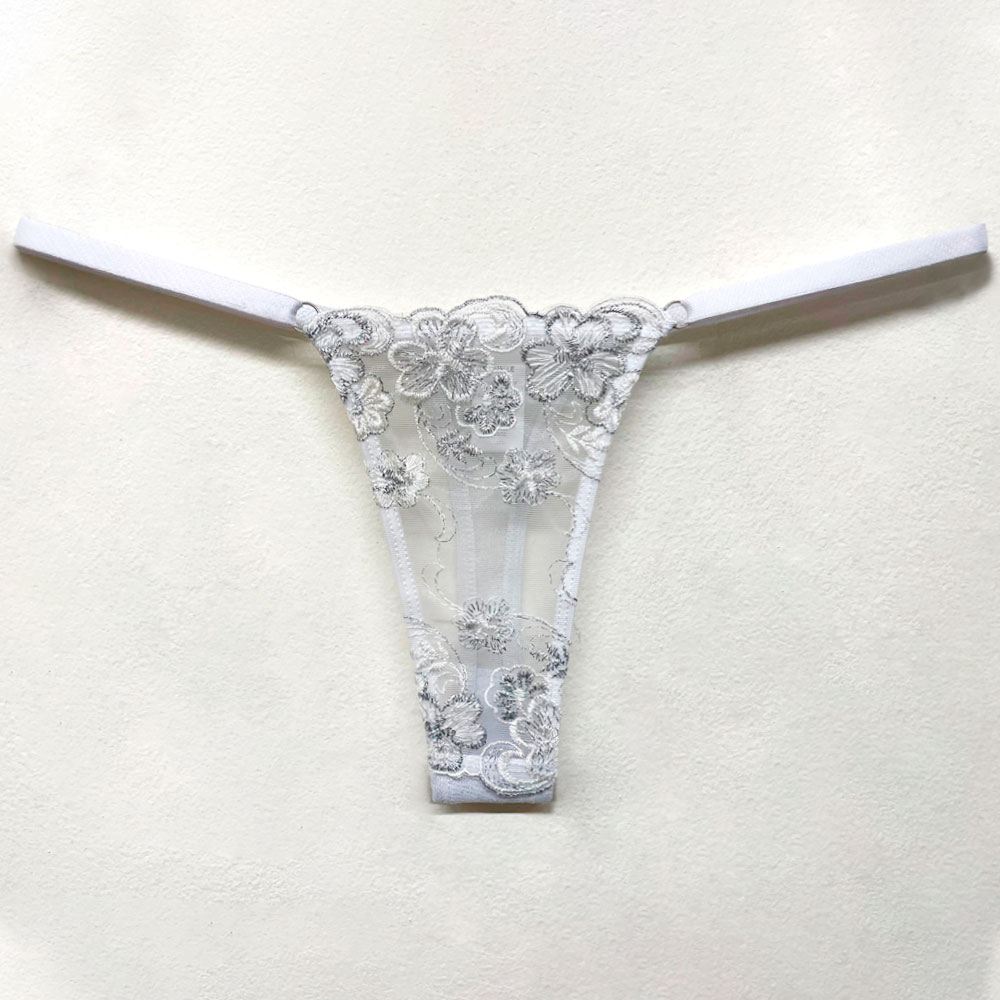 Calcinha String Fio Dental Sensual Sexy em Tule Bordado com Fios Prateados Branca | Vista frontal da calcinha esticada, revelando o tule bordado 