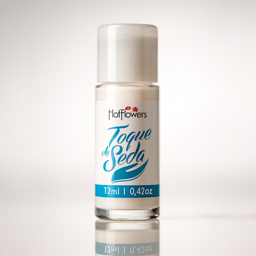 Lo��o para Masturba��o Siliconado Toque de Seda 12ml, frasco transparente com r�tulo branco e detalhes em azul claro, visto de frente em um fundo branco, destacando o brilho e a eleg�ncia do produto.
