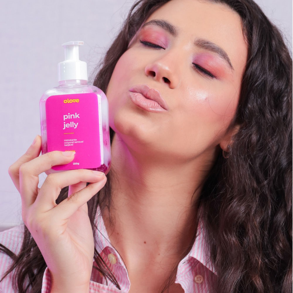 Mulher com maquiagem rosa segurando e beijando o frasco do Gel Hidratante Corporal Sensual Pink Jelly Sabor Chiclete
