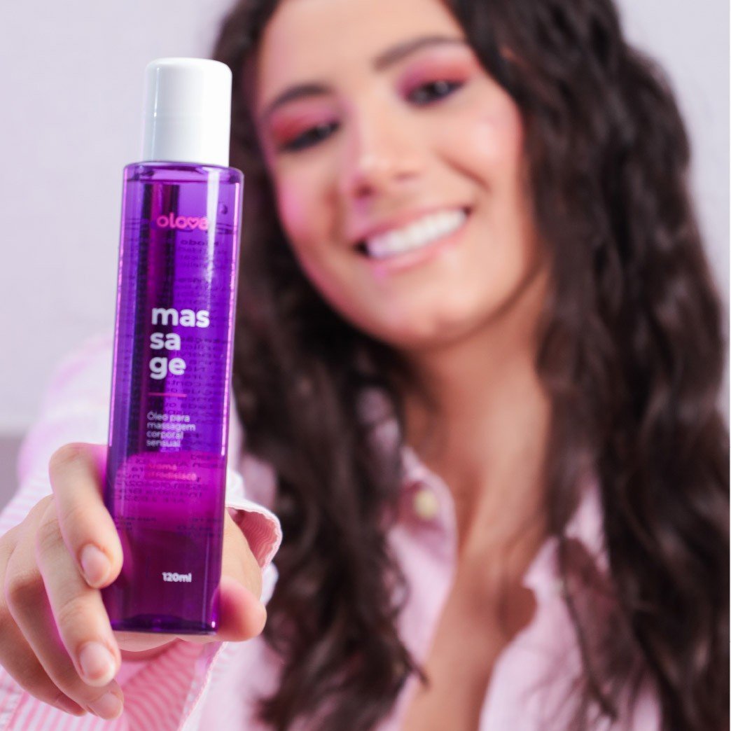 Mulher sorrindo segurando frasco roxo de �leo para Massagem Sensual Massage da Olove Cosm�tico, 120ml