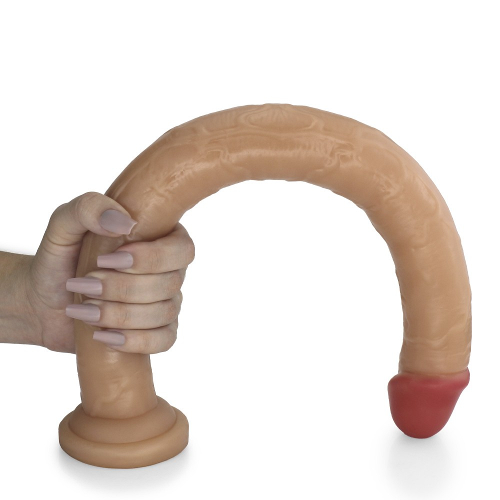 P�nis Gigante e Grosso com Escroto Piroc�o, curvado, com m�o segurando a base, demonstrando a flexibilidade do material