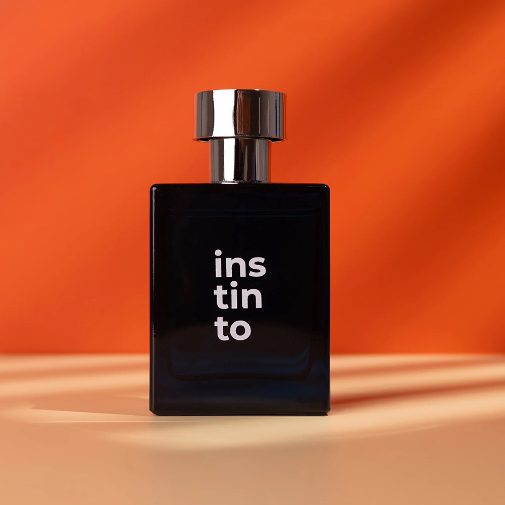 Perfume Olove Instinto, em close-up, com embalagem ao fundo