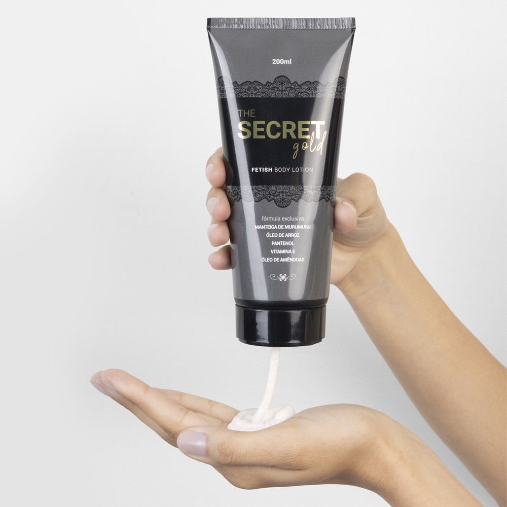 Pessoa aplicando o Creme Hidratante Corporal The Secret Gold 200ml na m�o, mostrando a textura do creme