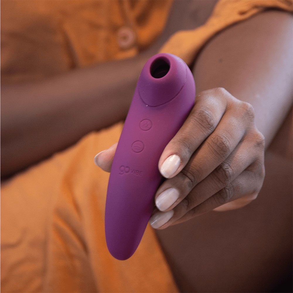 Sugador de Clit�ris Recarreg�vel Mia Roxo sendo segurado por uma m�o, destacando o corpo em silicone e os bot�es de controle
