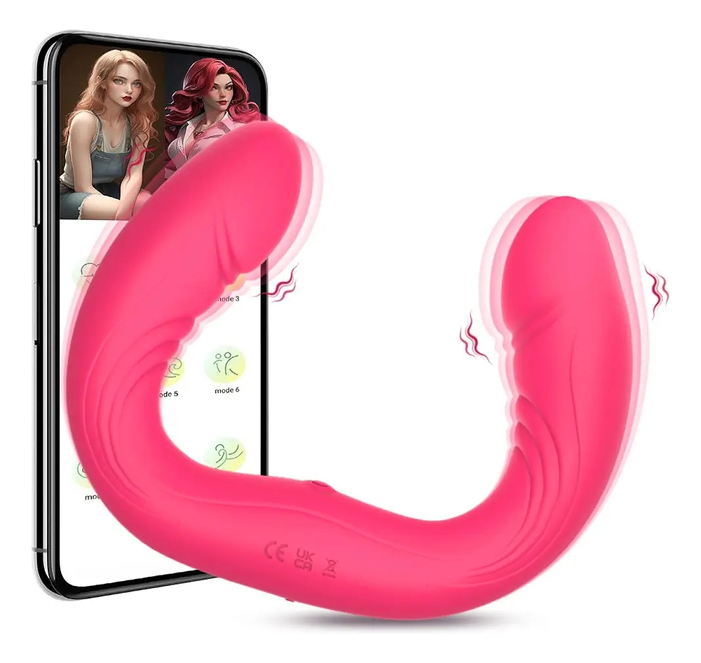 Vibrador duplo em silicone pink visto de lado, exibindo o formato em U e a textura em ondas, com um smartphone ao fundo exibindo a interface do aplicativo de controle
