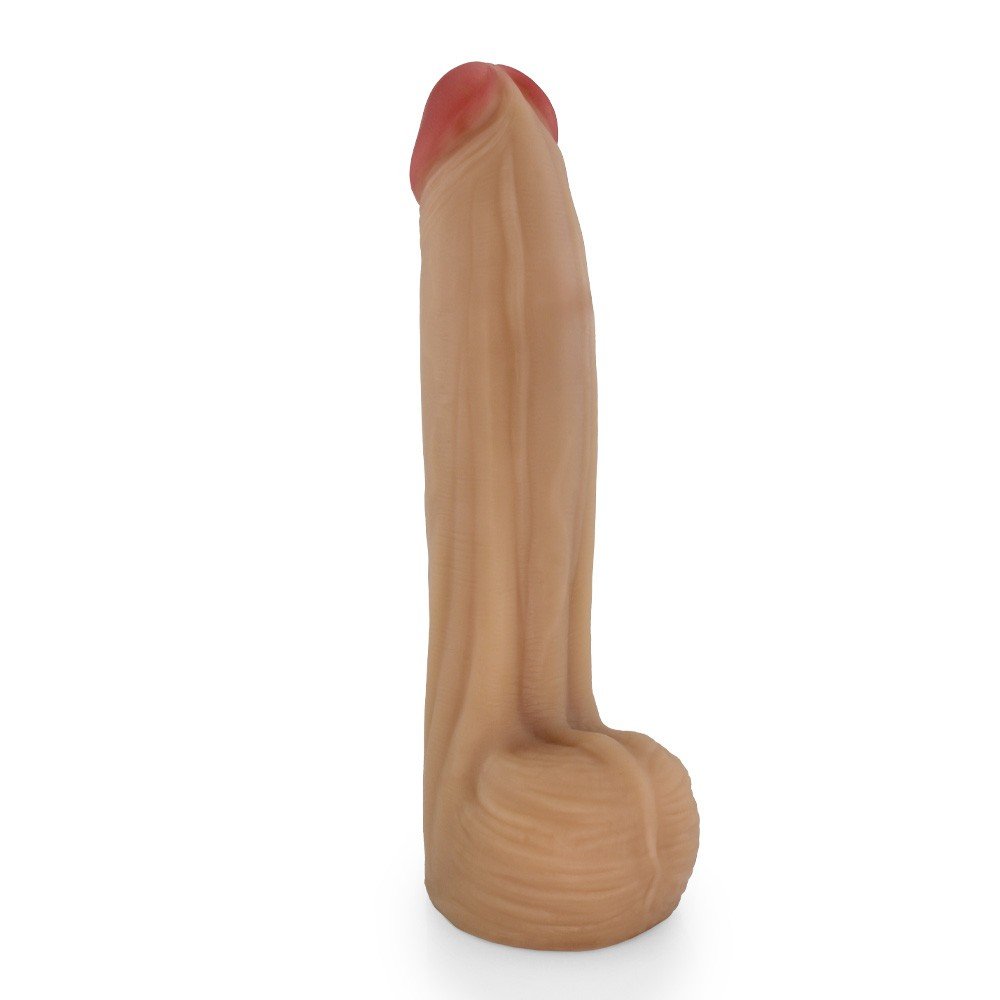 P�nis Real�stico com Escroto Bitelo - Dildo em PVC Flex�vel 29x6cm Bege visto de lado, mostrando a curva e a base robusta para manuseio confort�vel.