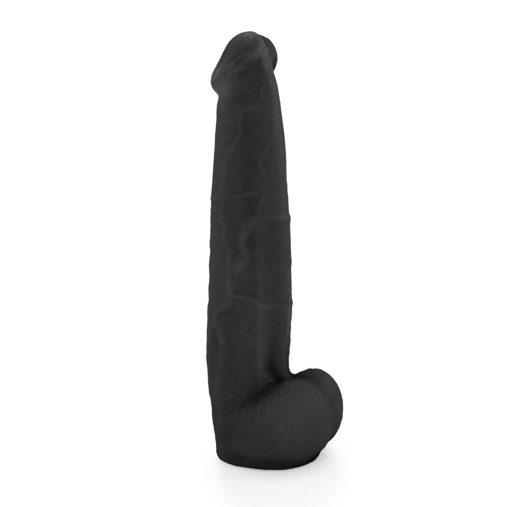 P�nis Real�stico com Escroto Jiboia - Dildo em PVC Flex�vel 31x6cm Preto em pose sugerindo flexibilidade, destacando o corpo liso e o escroto curvado