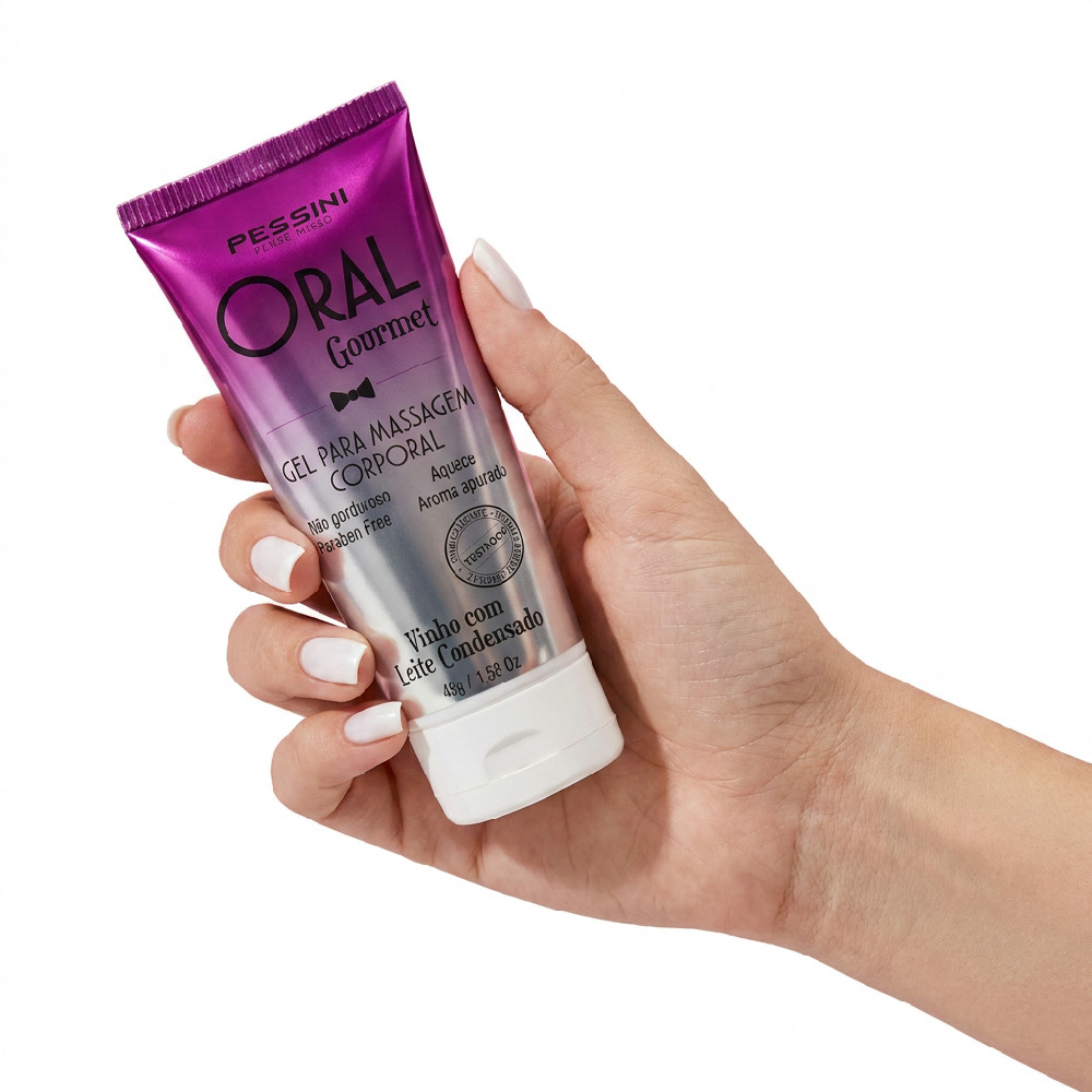 M�o segurando o Gel para Sexo Oral Oral Gourmet Vinho com Leite Condensado 45g, mostrando o tamanho compacto e praticidade